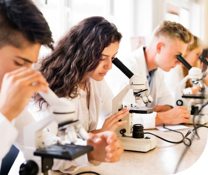 students looking through a microscope