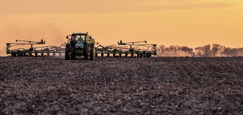 farm equipment in a field with golden sky behind